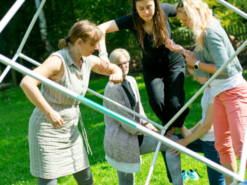 The female HY Workers crawl through the cube during the outdoor activity.