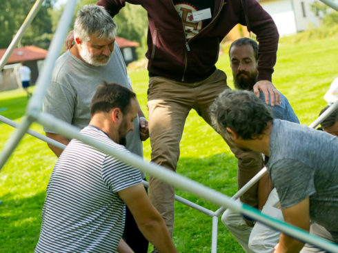 The male HY Workers crawl through the cube during the outdoor activity.